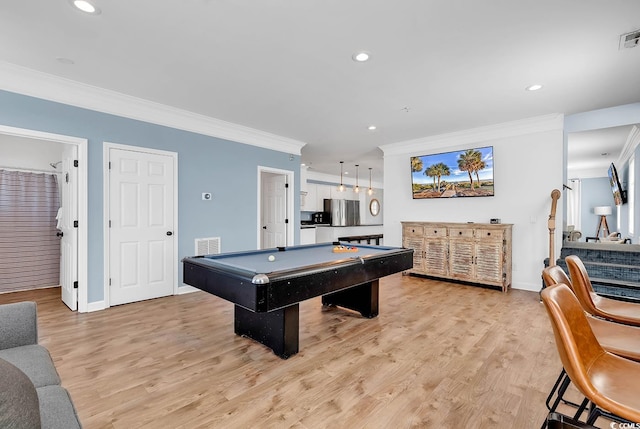 rec room with pool table, ornamental molding, and light wood-type flooring