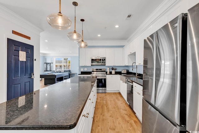 kitchen featuring light hardwood / wood-style floors, white cabinets, hanging light fixtures, stainless steel appliances, and a spacious island