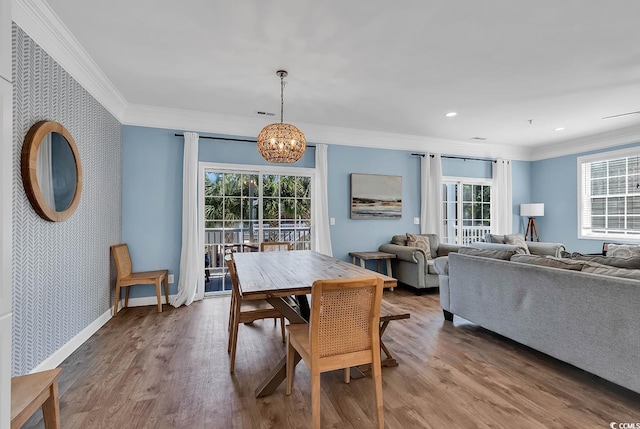 dining space with ornamental molding, a chandelier, and hardwood / wood-style floors