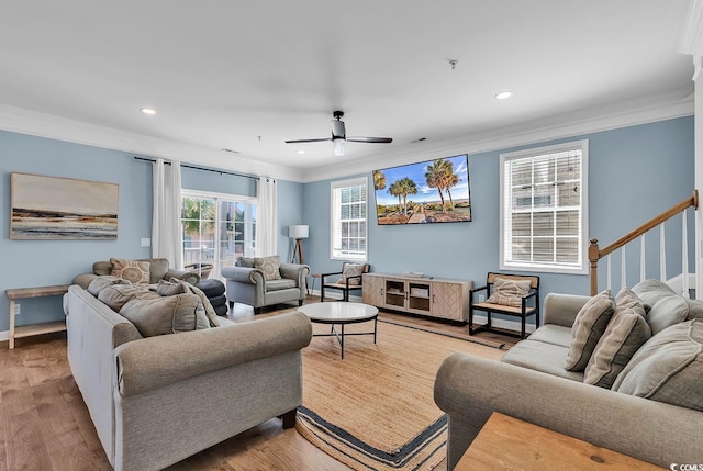 living room with light wood-type flooring, crown molding, and ceiling fan