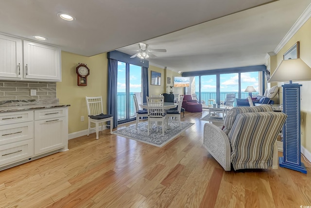 living room featuring a wealth of natural light, ceiling fan, and light wood-type flooring