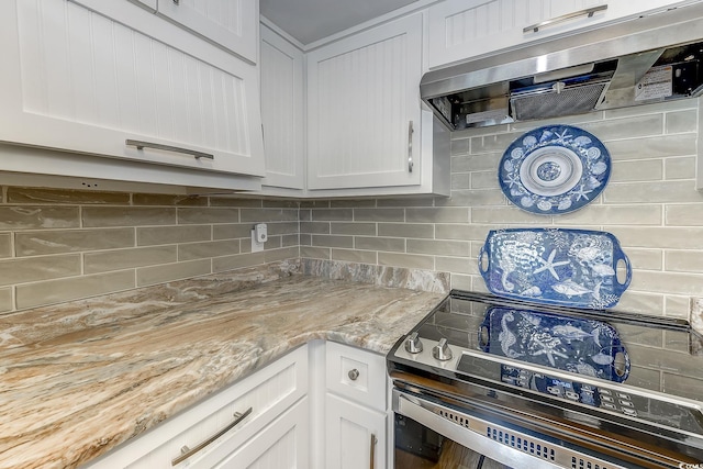 kitchen with light stone countertops, white cabinets, stainless steel electric range, and ventilation hood