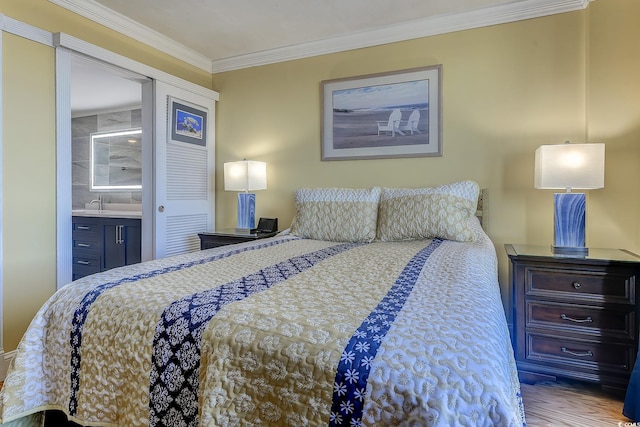 bedroom with light hardwood / wood-style flooring, ensuite bathroom, and crown molding