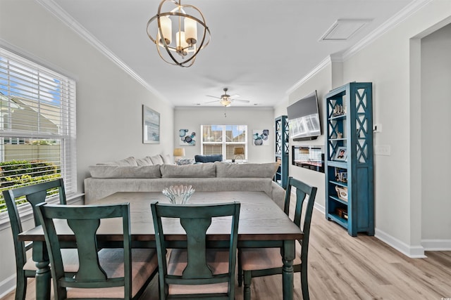 dining room with ceiling fan with notable chandelier, light hardwood / wood-style floors, and ornamental molding