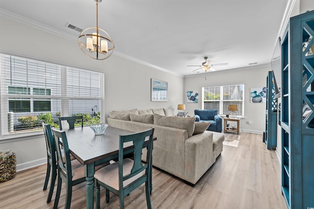 dining room featuring light wood-type flooring, ceiling fan with notable chandelier, and ornamental molding