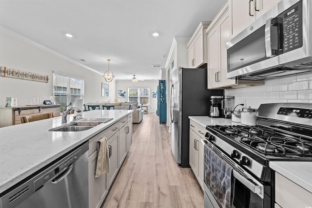 kitchen featuring light wood-type flooring, sink, decorative backsplash, stainless steel appliances, and crown molding