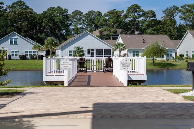 dock area with a lawn and a deck with water view