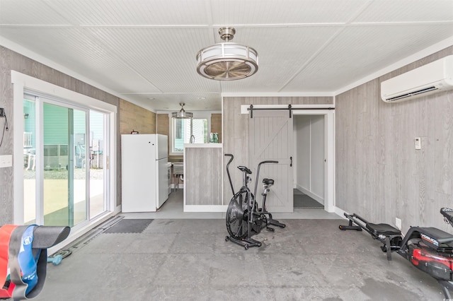 exercise area featuring a barn door and an AC wall unit