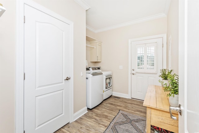 washroom with light hardwood / wood-style flooring, ornamental molding, independent washer and dryer, and cabinets