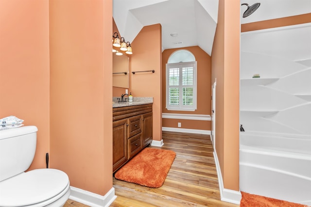 full bathroom with wood-type flooring, vanity, toilet, and vaulted ceiling