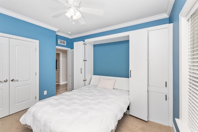 carpeted bedroom featuring ceiling fan and crown molding