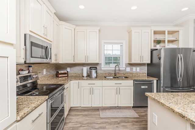 kitchen featuring light stone counters, sink, wood-type flooring, stainless steel appliances, and crown molding