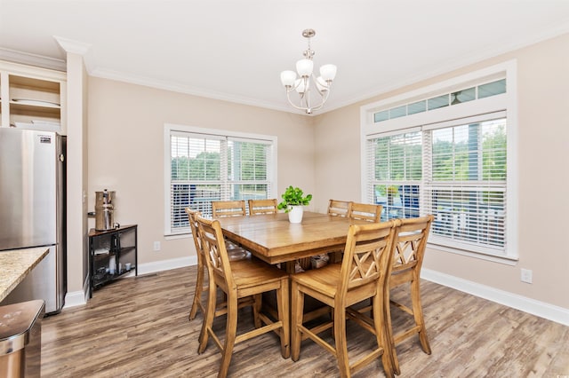 dining room featuring an inviting chandelier, crown molding, and hardwood / wood-style floors