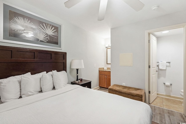 bedroom featuring ceiling fan, ensuite bath, and light hardwood / wood-style floors