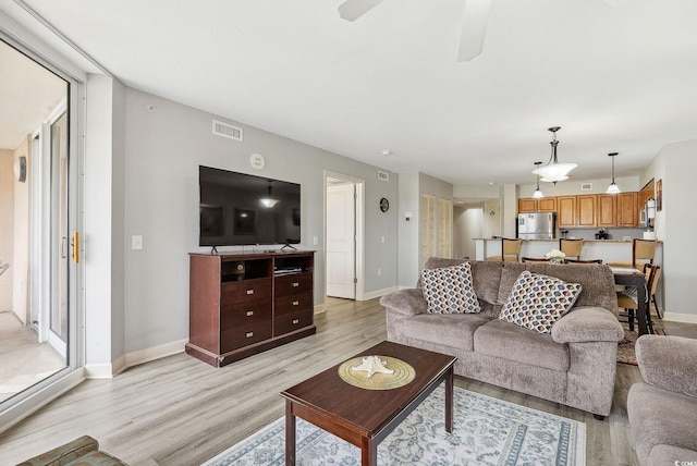 living room with ceiling fan and light hardwood / wood-style floors