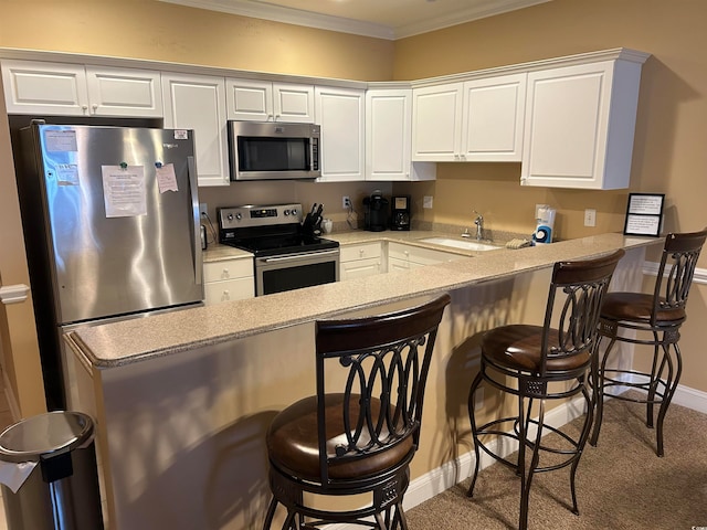 kitchen featuring stainless steel appliances, white cabinets, a breakfast bar area, and sink