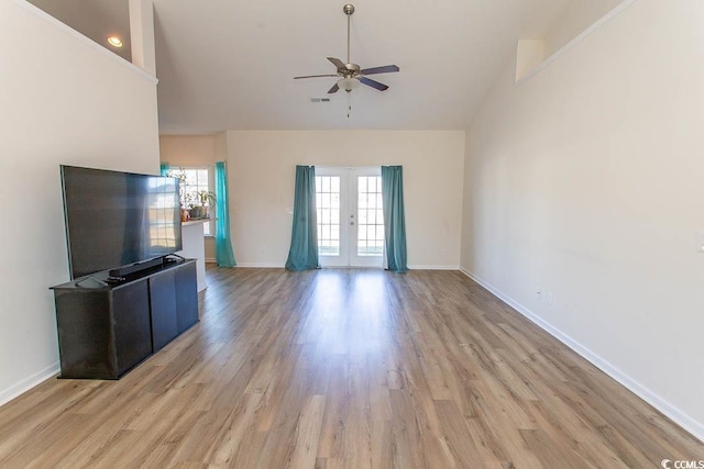 unfurnished living room featuring french doors, high vaulted ceiling, light hardwood / wood-style flooring, and ceiling fan