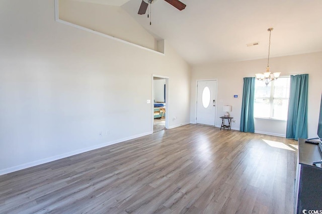 unfurnished living room with hardwood / wood-style floors, high vaulted ceiling, and ceiling fan with notable chandelier