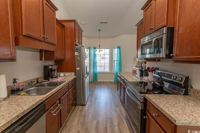 kitchen featuring pendant lighting, light hardwood / wood-style floors, sink, and stainless steel appliances