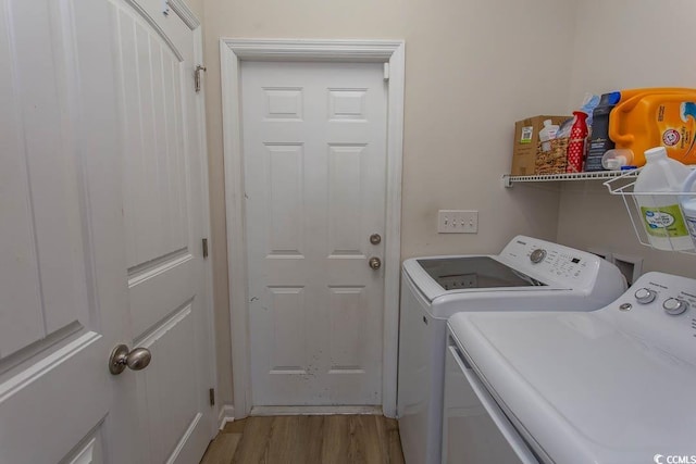 clothes washing area featuring washer and dryer and light wood-type flooring