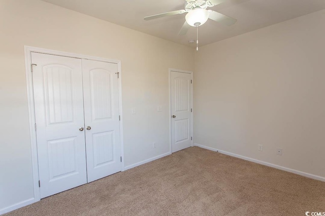 unfurnished bedroom with ceiling fan, light carpet, and a closet