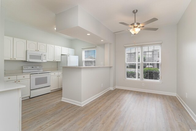 kitchen featuring light countertops, light wood-style flooring, white appliances, baseboards, and white cabinets