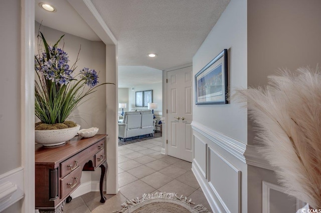 corridor with light tile patterned flooring and a textured ceiling