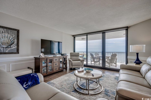 living room featuring floor to ceiling windows, a textured ceiling, and hardwood / wood-style floors