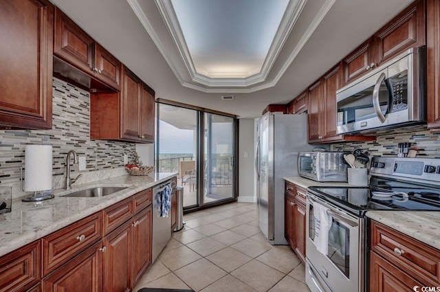 kitchen featuring light stone countertops, stainless steel appliances, backsplash, and sink