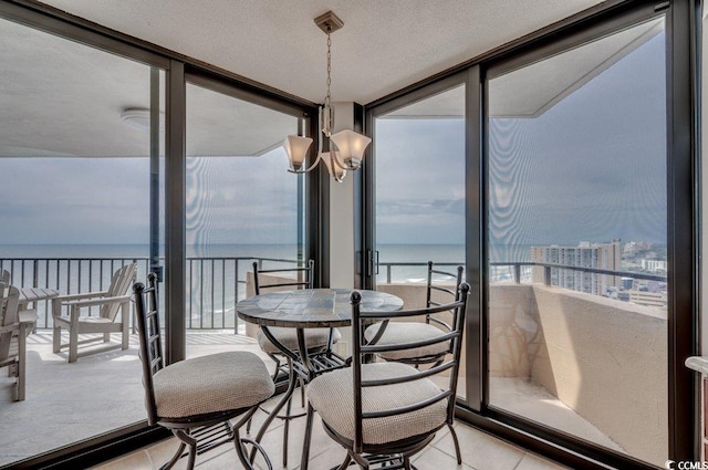 sunroom featuring an inviting chandelier and a water view