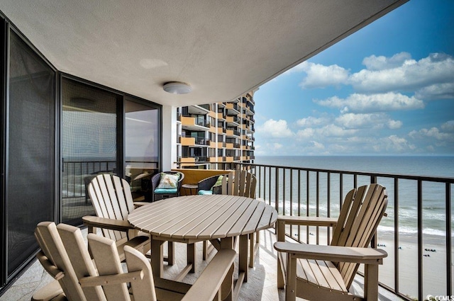 balcony with a water view and a beach view