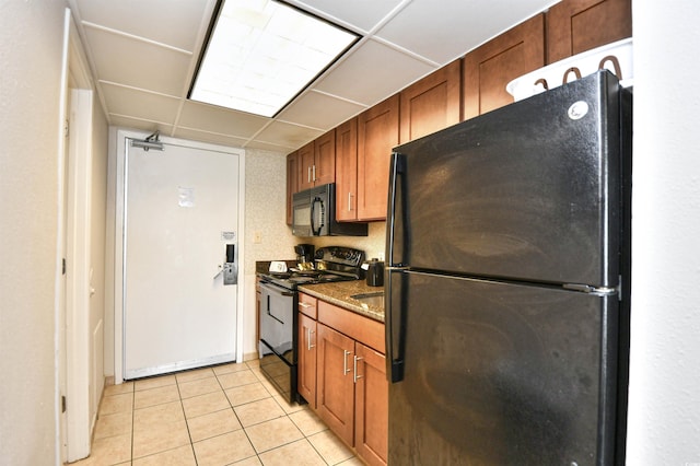 1105 S Ocean Blvd Unit 1044, Myrtle Beach, SC 29577 - kitchen with black appliances, light tile patterned floors, brown cabinets, a paneled ceiling, and dark stone counters