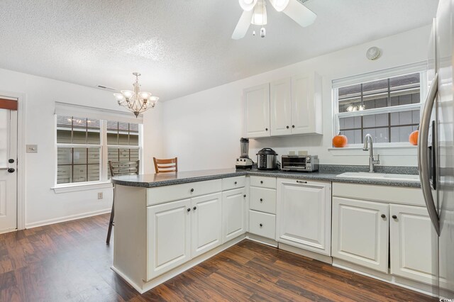 1356 Tranquility Ln, Myrtle Beach, SC 29577 - kitchen with a peninsula, dark countertops, a chandelier, dark wood-style floors, and a textured ceiling