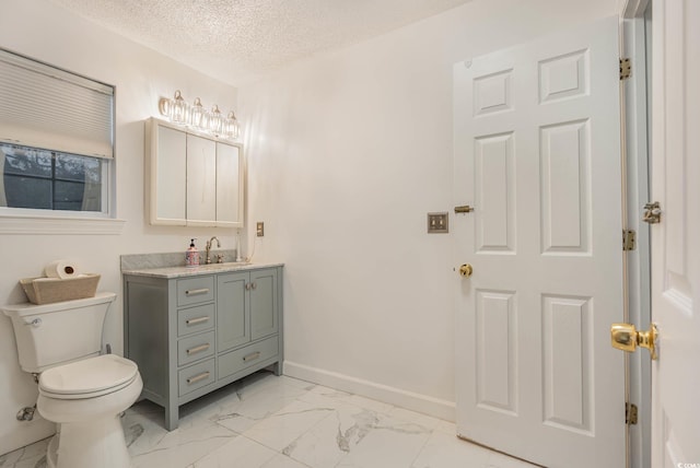 bathroom featuring a textured ceiling, vanity, and toilet