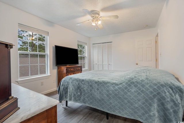 bedroom with a closet, ceiling fan, a textured ceiling, and dark hardwood / wood-style flooring