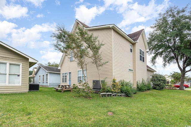 exterior space with central AC unit and a yard