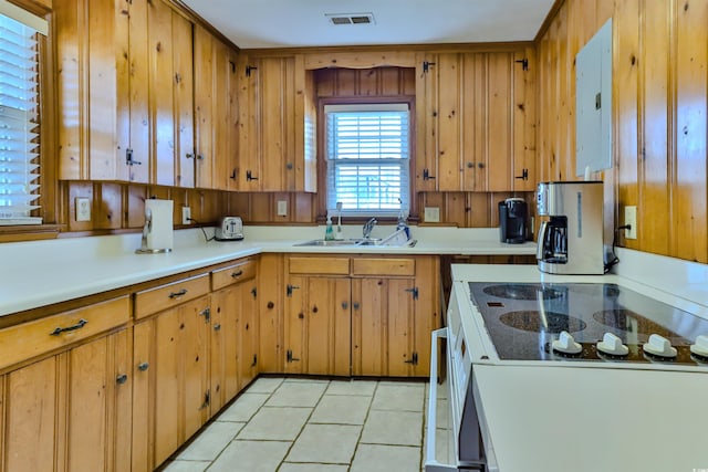 kitchen featuring electric panel, white range oven, light tile patterned flooring, and sink