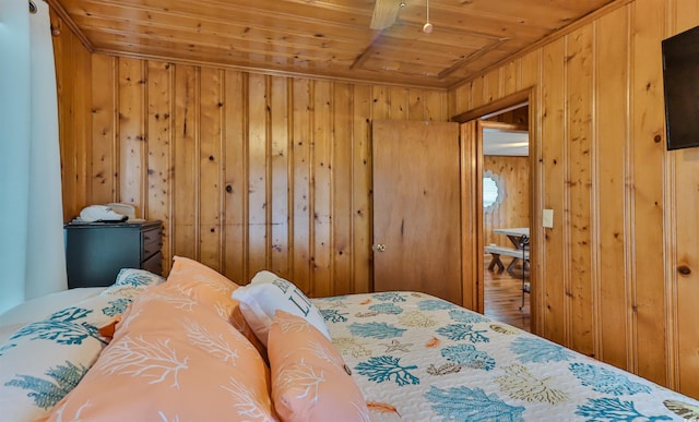 bedroom with wooden ceiling, wood-type flooring, wood walls, and ceiling fan