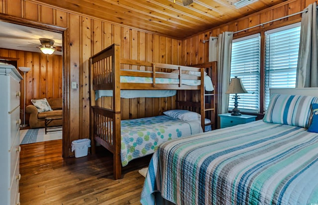 bedroom with wood ceiling, wooden walls, ceiling fan, and hardwood / wood-style floors