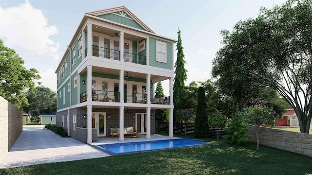 rear view of house with a balcony, a lawn, and a patio