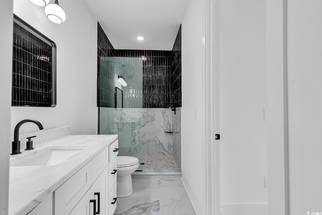 bathroom featuring vanity, toilet, and tiled shower