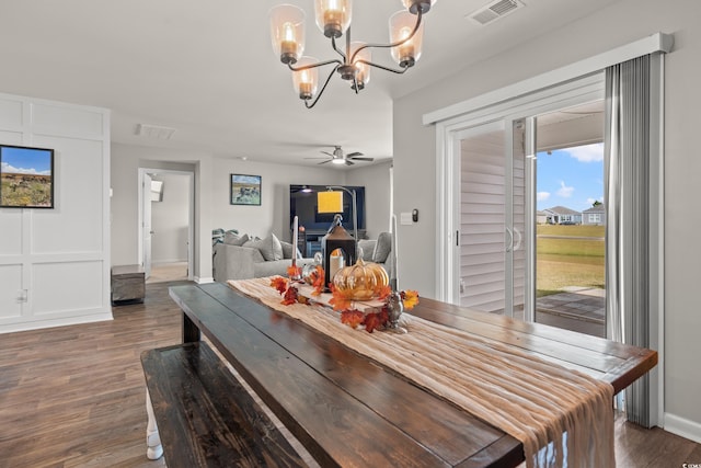 dining area featuring dark hardwood / wood-style floors and ceiling fan with notable chandelier