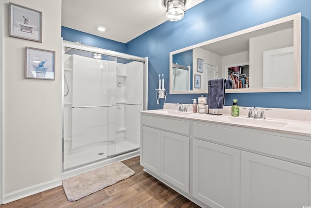 bathroom with walk in shower, vanity, and hardwood / wood-style flooring