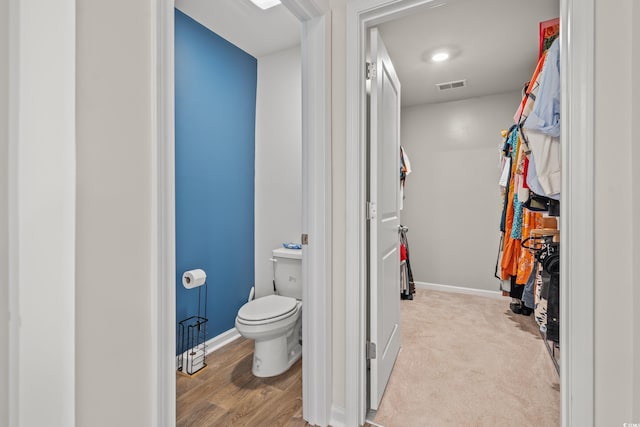 bathroom featuring toilet and wood-type flooring