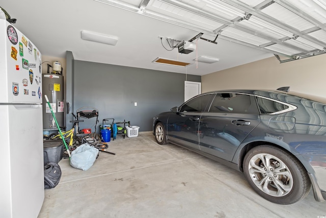 garage with water heater, white fridge, and a garage door opener