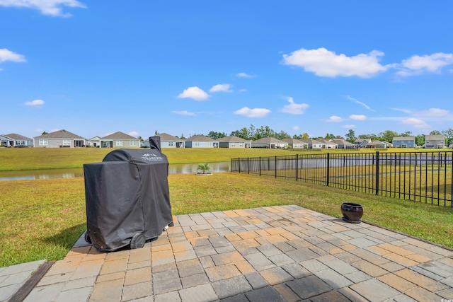 view of patio with grilling area and a water view