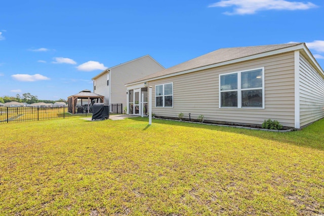 rear view of property with a patio area, a yard, and a gazebo