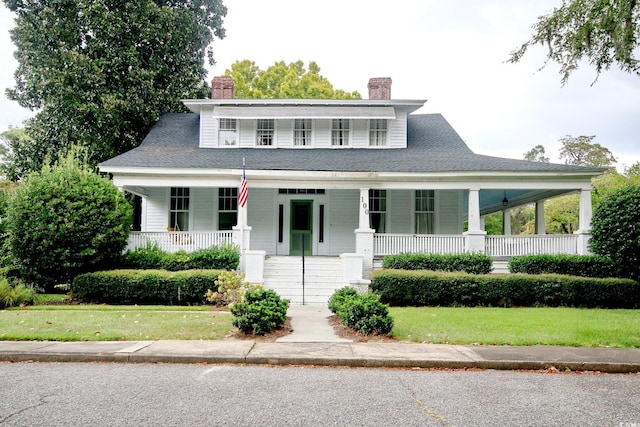 farmhouse with a front yard and covered porch