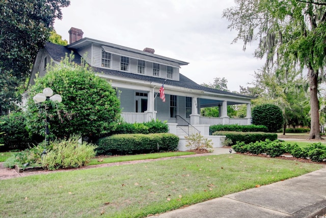 view of front of house with a porch and a front yard