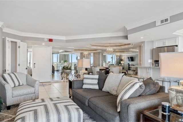 tiled living room featuring a raised ceiling, ornamental molding, and an inviting chandelier